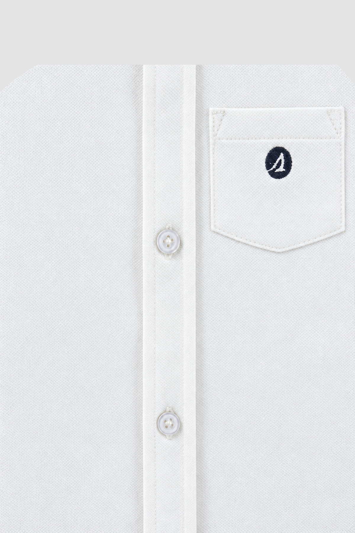 gros plan bouton et poche à logo de la chemise blanche Sperry