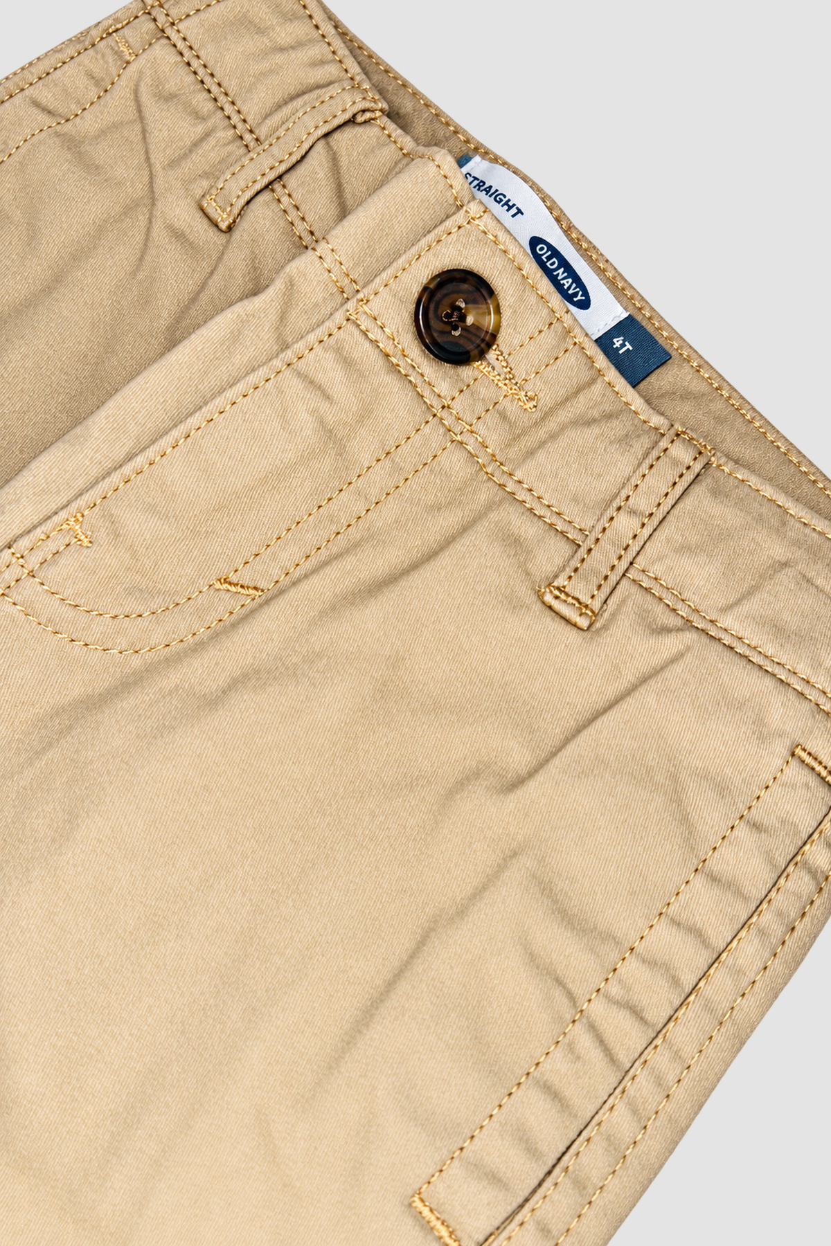 gros plan ceinture, bouton et étiquette du pantalon beige Old Navy